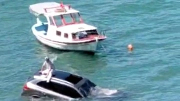 Balıkesir'de ilginç anlar: Denize uçan otomobilinin üzerinde oturup yardım bekledi